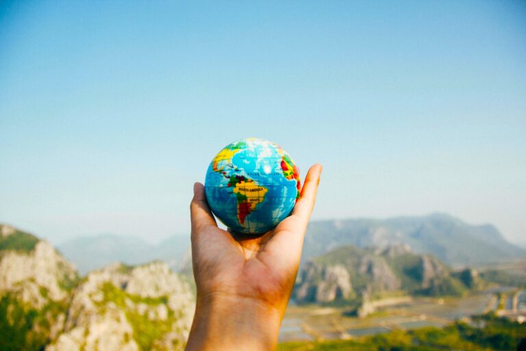 Person, Die World Globe Facing Mountain Hält Foto: Porapak Apichodil Pexels