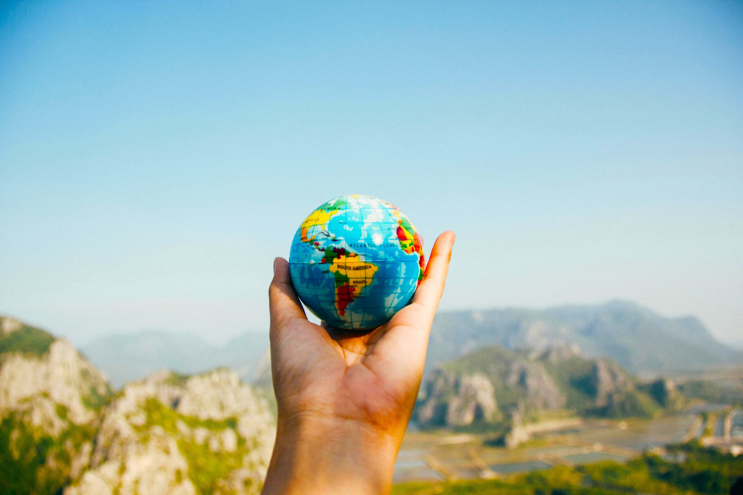 Person, Die World Globe Facing Mountain Hält Foto: Porapak Apichodil Pexels